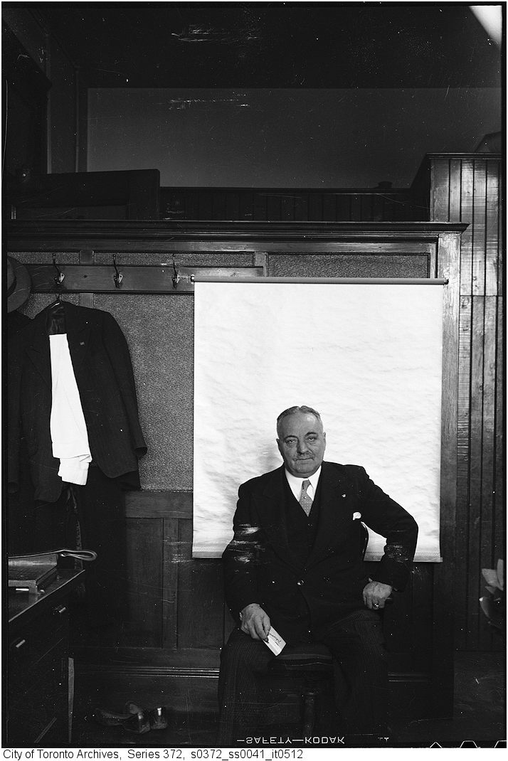 John M. Innes, Controller; seated, full face